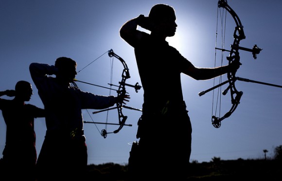 Three men shooting bows