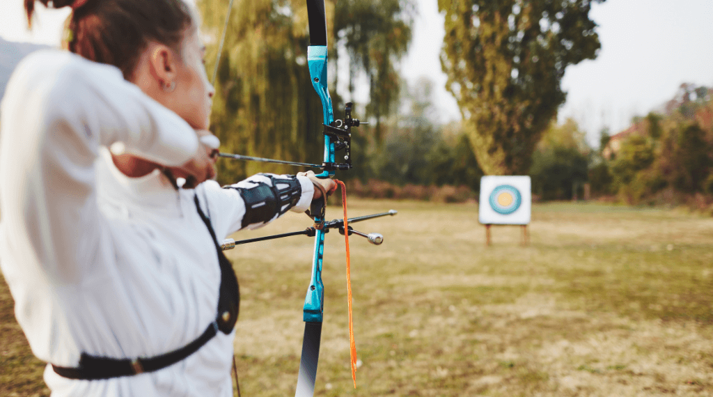 A young woman shooting with a recurve bow.
