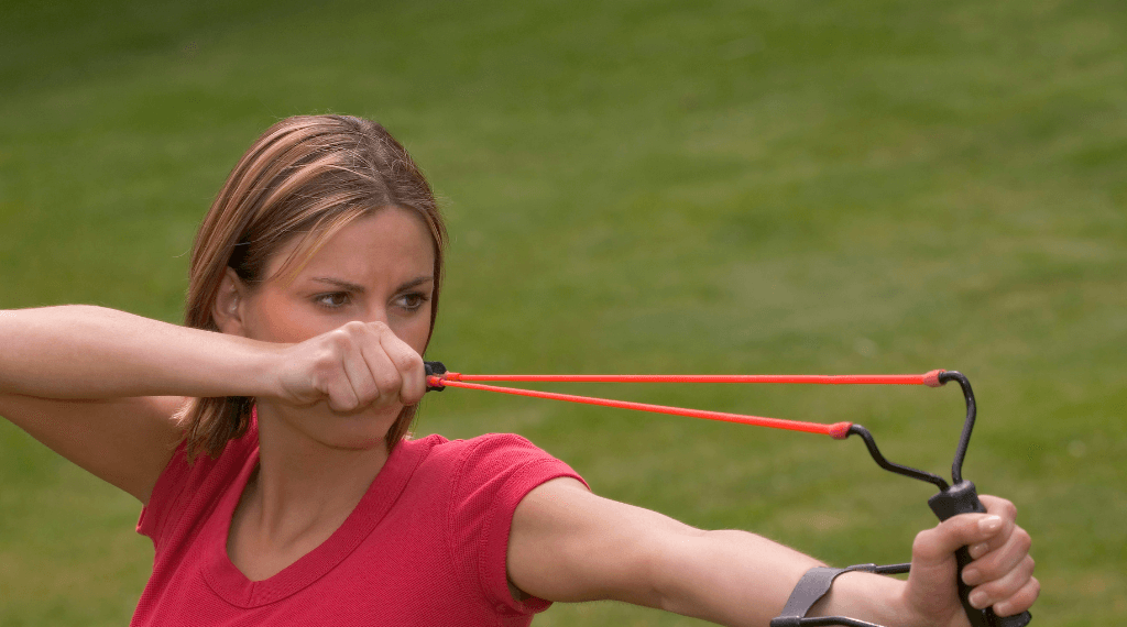 A woman shooting with a slingshot.