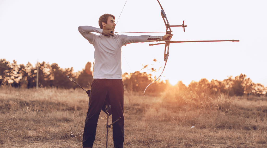 A man shooting with a recurve bow.