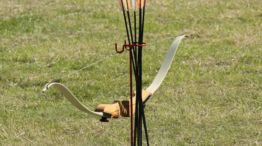 A recurve bow on a bow stand.